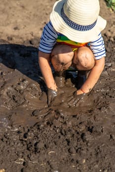 Child playing in mud. Selective focus. Kid.