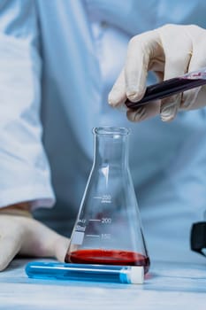 A scientist holds a test tube filled with green liquid in a laboratory, surrounded by various lab equipment. The image highlights the focus and precision involved in scientific research