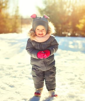 Winter portrait funny smiling child playing in sunny day