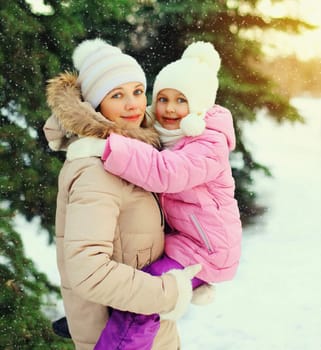 Winter happy mother and child over christmas tree and snowflakes