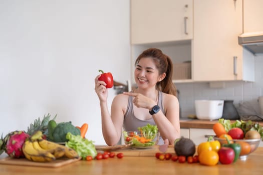 Young Asian healthy beautiful woman with casual clothes is smile and slicing fresh fruit to diet at home in kitchen in holiday.