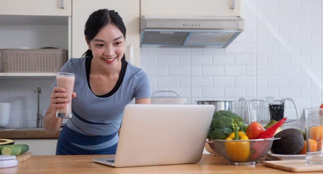 Beauty healthy asian woman making fruit smoothie with blender. woman drinking glass of fruit smoothie in kitchen. Diet concept. healthy drink.