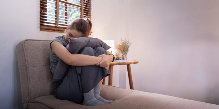 Young Asian woman in bedroom feeling sad tired and worried suffering depression in mental health.