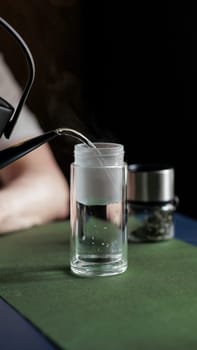 A serene and peaceful moment occurs as hot water gently pours into a clear glass, ideal for tea or coffee enthusiasts