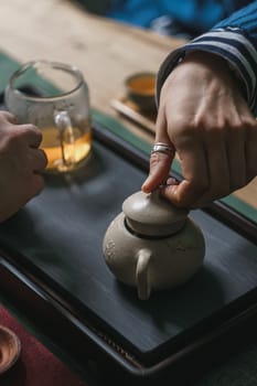 A serene and peaceful scene of tea preparation featuring a beautifully crafted clay teapot and a delicate glass cup