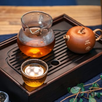 Enjoy a serene tea setup with a beautiful glass teapot and an elegant cup on a charming wooden tray