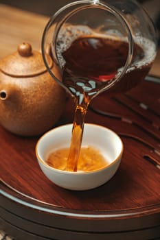 A serene moment as tea pours into a beautifully crafted cup, showcasing its rich color and exquisite teaware