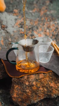 Pouring freshly brewed tea into beautiful cups while surrounded by stunning natural scenery and landscapes