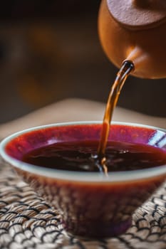 Enjoy the beauty of tea pouring into a vibrant bowl, showcasing artisan craftsmanship and tranquility.