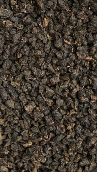 This textured image of dried black tea leaves is perfect for culinary and beverage projects needing visual appeal