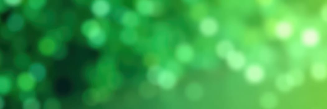 Vivid green bokeh lights shimmer softly in the background, enhancing the lively ambiance of a warm afternoon in a natural outdoor location surrounded by greenery.