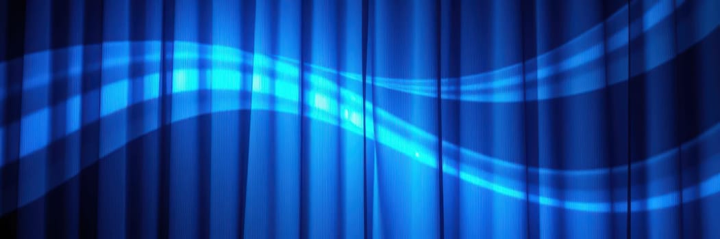 A bright blue stage curtain hangs in a theater, illuminated with soft lighting. Wave patterns enhance the dramatic atmosphere, setting the stage for the upcoming performance.