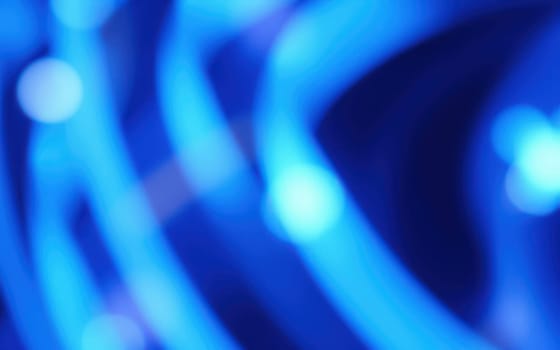 Abstract patterns of glowing blue lights create a mesmerizing effect in an urban environment at night, showcasing the lively atmosphere of the event.