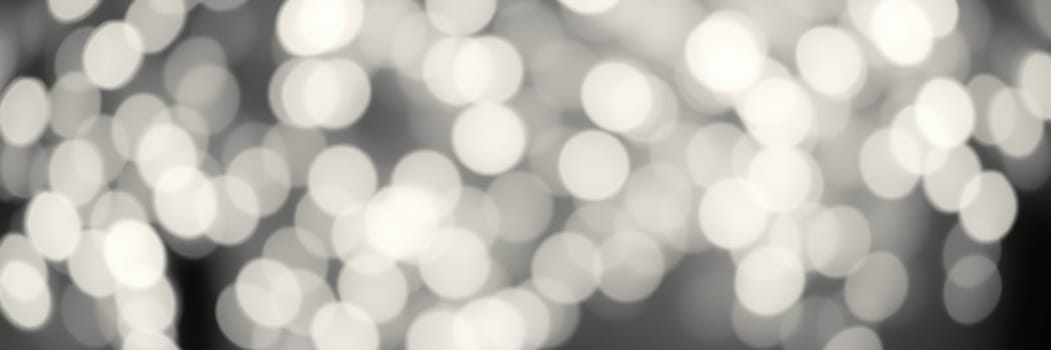 A beautiful display of soft bokeh lights fills the frame, creating a warm and enchanting ambiance at an outdoor gathering in the evening, perfect for socializing.