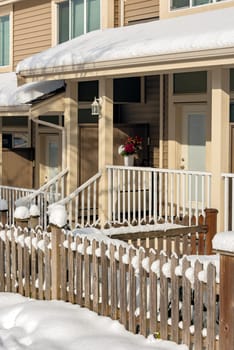 Small front yard, porch and entrance of residential townhouses on winter season in Canada.