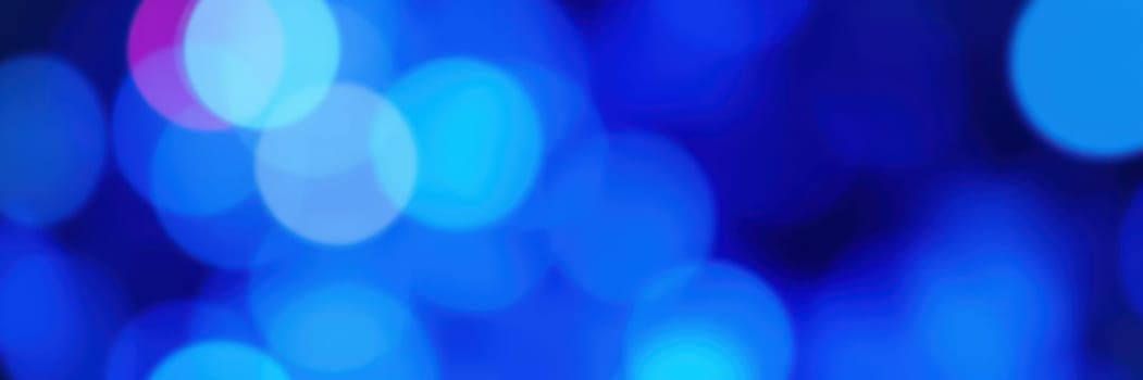 Colorful blue bokeh lights create a lively ambiance during an evening event, enhancing the festive mood and captivating the audience with their brilliance.