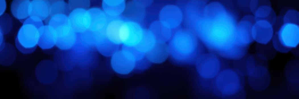 The beautiful blue bokeh lights illuminate the night sky during an outdoor celebration, creating a dreamy and festive atmosphere for guests to enjoy and socialize.
