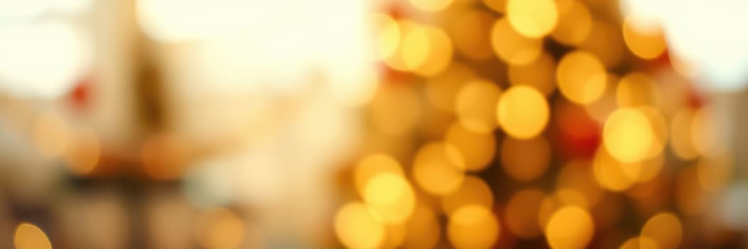 A beautifully decorated Christmas tree glows with soft yellow lights, filling the room with warmth and holiday spirit. The background features festive decor enhancing the atmosphere.