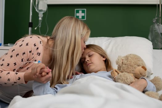A mother comforts her sick child in a hospital bed, showing deep love and care during difficult times