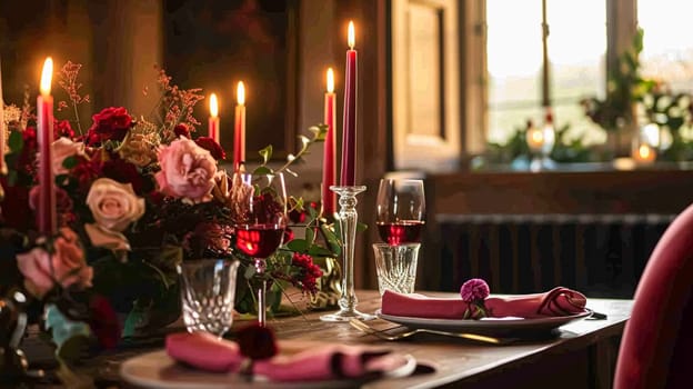 Festive table setting with candles and arrangement of beautiful red flowers. Holiday concept. High quality photo