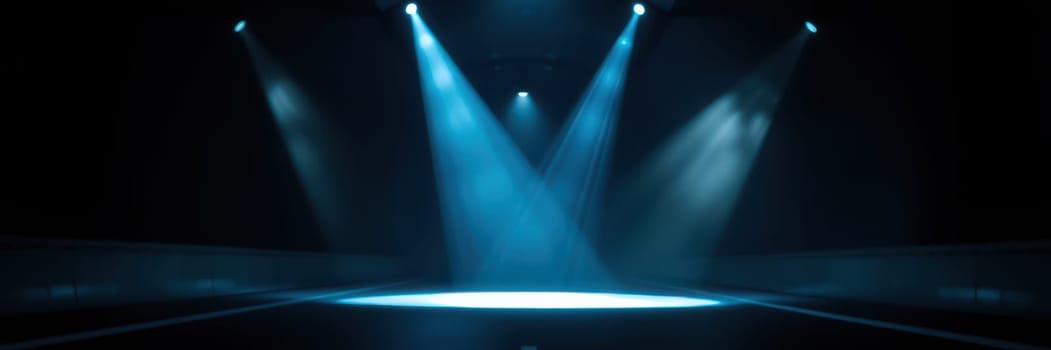 Bright blue spotlights shine down on an empty stage, creating dramatic shadows and a captivating atmosphere. This lighting sets the mood for an upcoming performance or event.