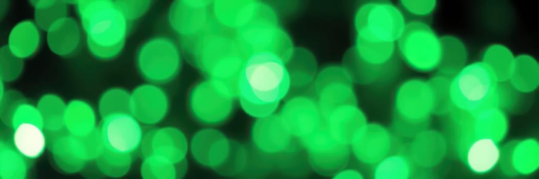 Softly glowing green bokeh lights fill the dark space, adding a vibrant and energetic feel to the surroundings during a nighttime event or celebration.
