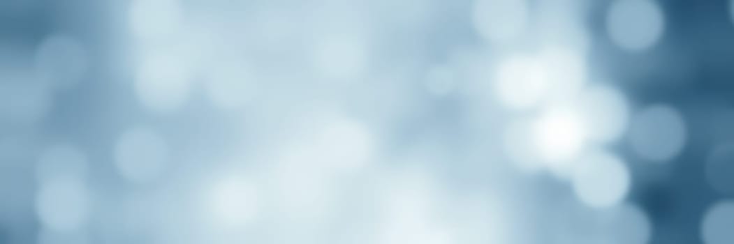 A soft blue bokeh background showcases gentle, blurred circles of light, offering a tranquil and visually appealing backdrop suitable for artistic and design endeavors.