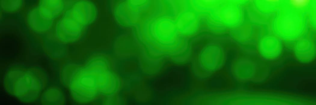 A vibrant background showcases various shades of green in a striking bokeh effect, creating a lively and energetic ambiance suitable for various design purposes.