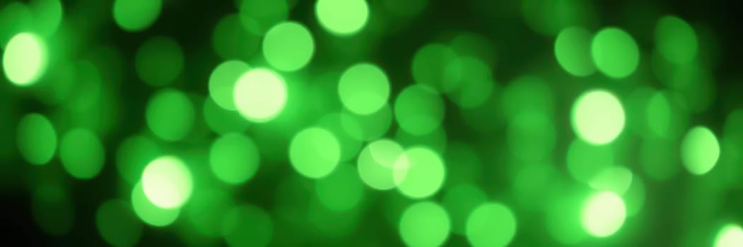 Bright green bokeh lights shimmer against a dark background, creating a lively and festive atmosphere ideal for parties or special occasions, evoking joy and excitement.