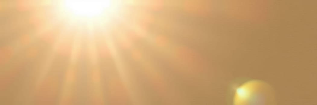 A vibrant sun shines brightly over a clear sky, casting warm golden hues and creating a serene atmosphere during a calm afternoon.