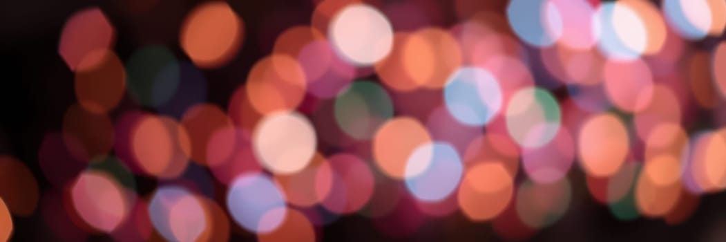 Blurred, colorful bokeh lights illuminate the night, creating a lively atmosphere filled with joy and excitement from an evening celebration in the city.