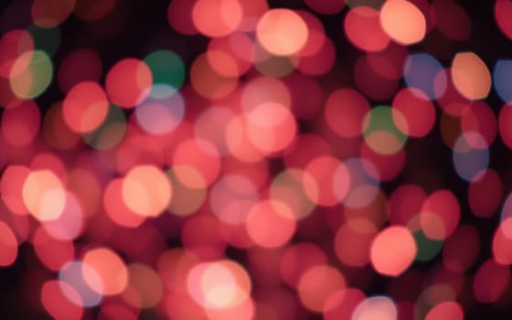 Bright, swirling colors form a captivating display of bokeh effects at a lively celebration during the evening, enhancing the festive atmosphere.