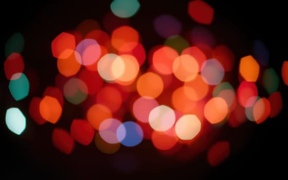 A dazzling array of colorful bokeh lights fills the space, evoking a joyful and festive atmosphere during an evening celebration. The blurred shapes enhance the mood.