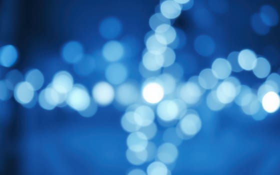 A collection of soft blue bokeh lights brightens the surroundings, creating a calming and inviting environment perfect for winter festivities and evening gatherings.