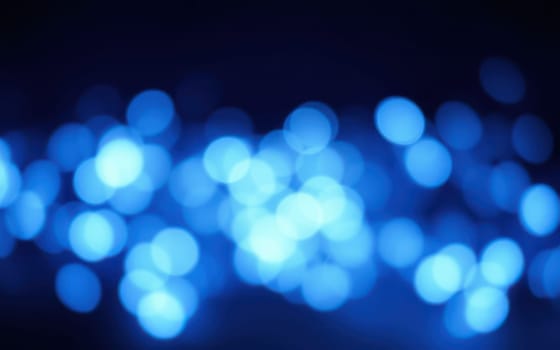 Soft blue bokeh lights fill the background, creating a serene ambiance. The twinkling hues suggest a nighttime gathering or event, ideal for relaxation.
