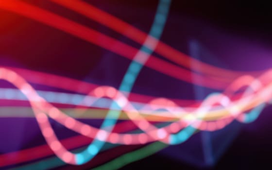 Vibrant light trails swirl in a mesmerizing pattern against a dark background, showcasing various colors and movement that create an energetic atmosphere.