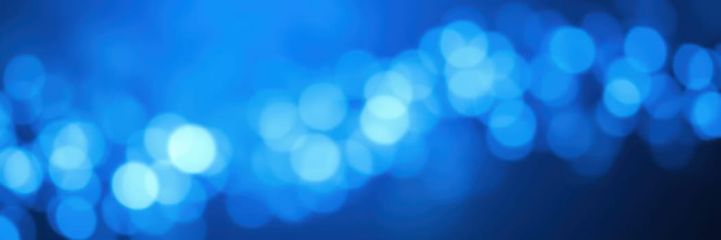 An array of soft blue bokeh lights fills the background, creating a serene and tranquil ambiance. This stunning visual effect captivates the viewer with its gentle glow.