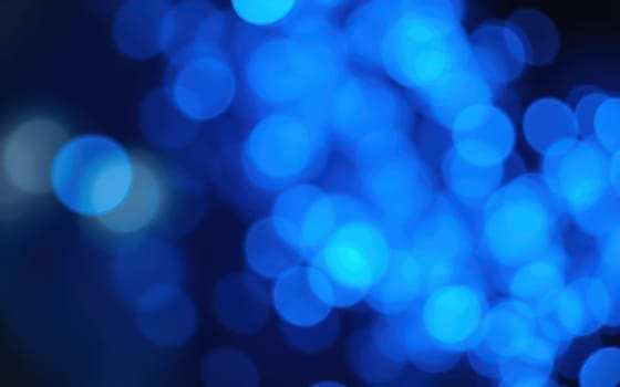 Soft, glowing blue lights fill the background, creating a dreamy and enchanting atmosphere. The blurred bokeh effect enhances the serene feel of the scene.