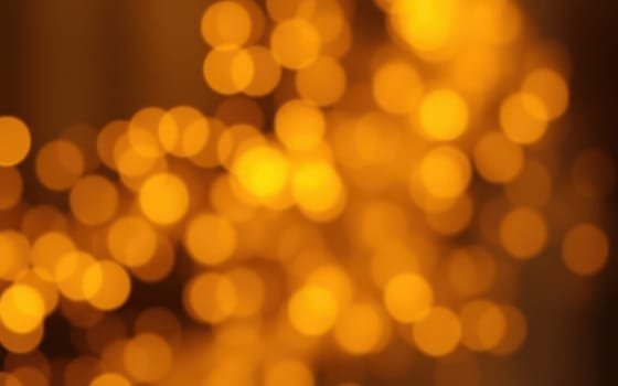 Warm golden lights shimmer softly, filling the atmosphere with a sense of joy and elegance during a festive evening event. The ambiance is perfect for celebration.