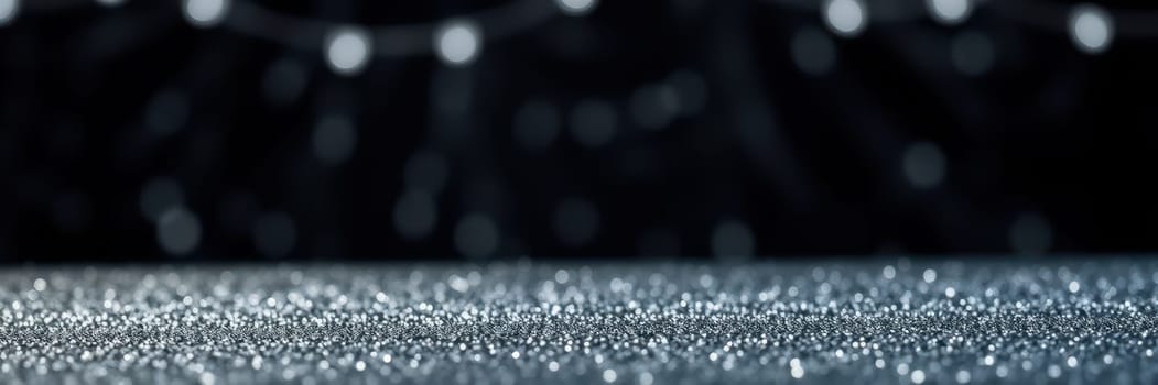 A shimmering surface is blanketed with tiny reflective particles under soft, blurred lights. The warm ambiance suggests a celebration or holiday gathering.