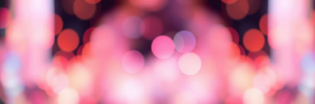 Blurred bokeh lights create a vibrant atmosphere at an energetic gathering, where attendees enjoy music and socializing amid colorful illumination.