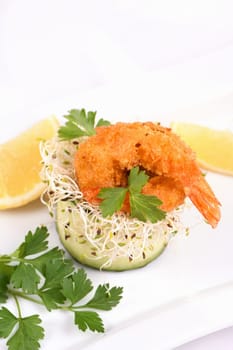 Cucumber appetizer with fried breaded shrimp on a bed of microgreens