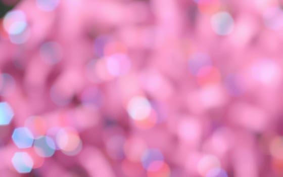 This vibrant scene showcases a blur of pink hues mixed with shimmering light reflections, creating a whimsical atmosphere perfect for a celebration or party.
