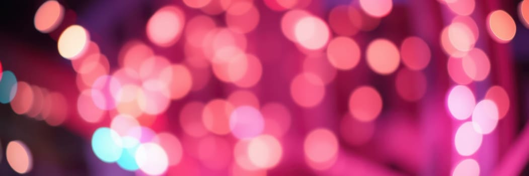 Soft glows of pink and purple lights create a dreamy atmosphere, illuminating a night setting that evokes feelings of celebration and warmth.