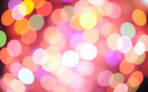 A blur of colorful lights fills the background, creating a festive and lively atmosphere during an evening celebration. The scene evokes joy and excitement, enhancing the event's spirit.