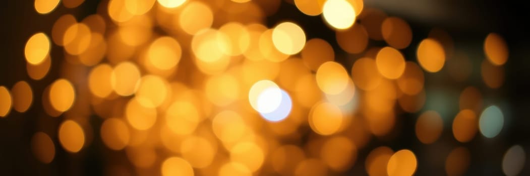 Shimmering golden lights illuminate an outdoor space, enhancing a joyful ambiance during evening festivities. People mingle and celebrate together under the glowing lights.