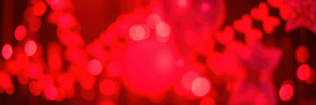 Bright red lights illuminate a festive setting filled with decorations, creating a lively ambiance for an evening celebration or event. The warm glow enhances the cheerful mood.