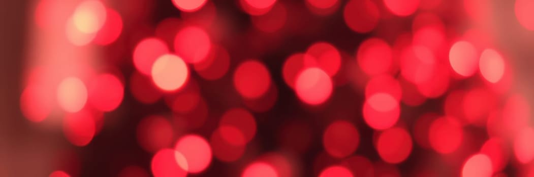 Colorful bokeh lights in shades of red fill the background, setting a joyful and warm atmosphere for a home celebration during the holiday season.