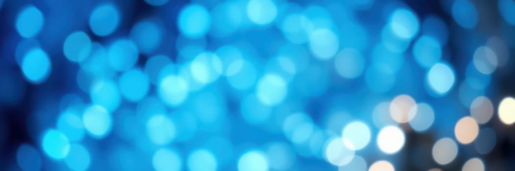 Soft, blurred bokeh lights shine in shades of blue and white, creating a dreamy background atmosphere for a nighttime event filled with excitement and joy.