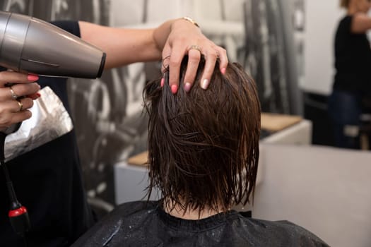 A skilled stylist blowdrying hair in a contemporary salon atmosphere, demonstrating exceptional hair care expertise